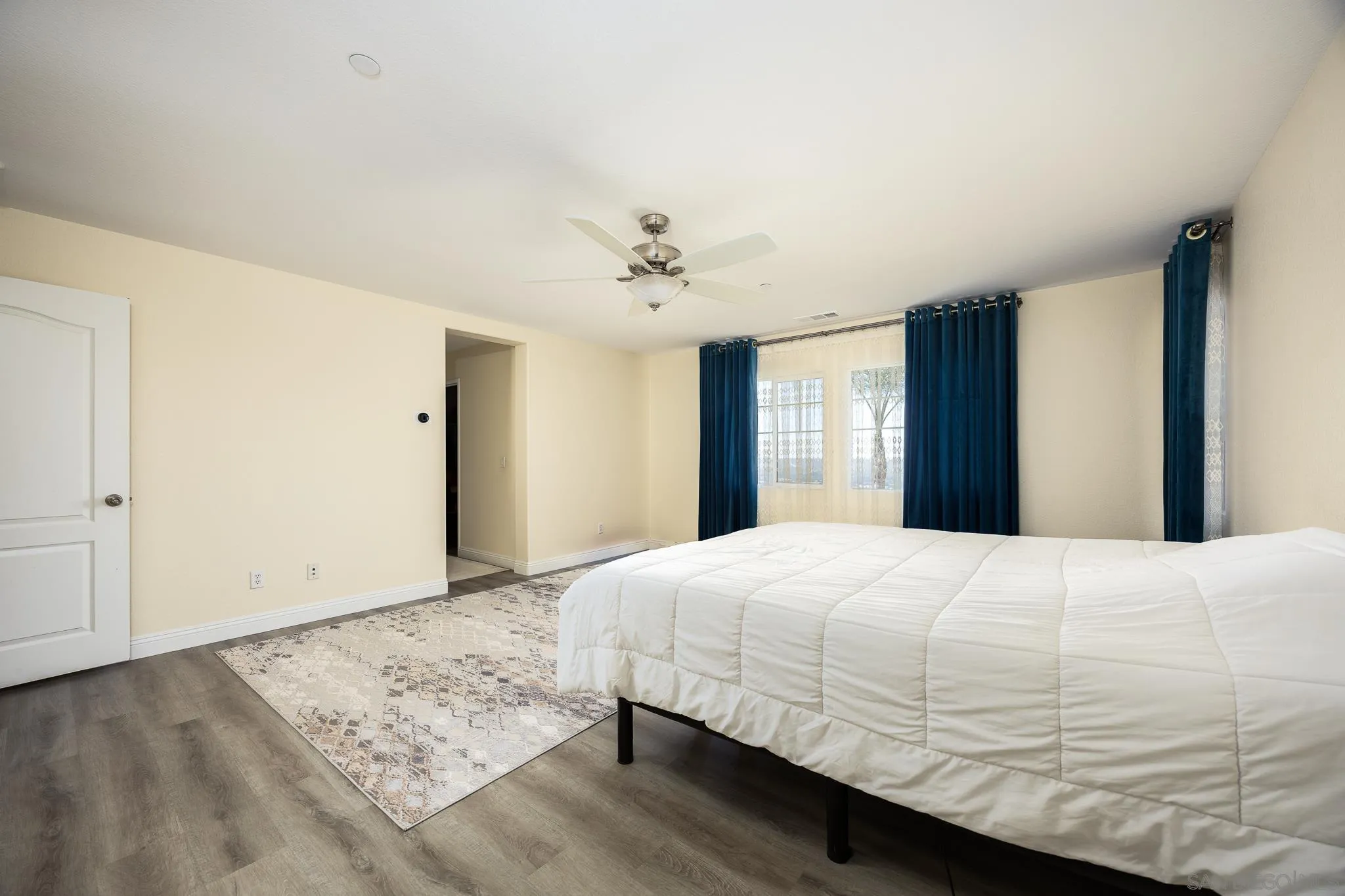 5120 Sevilla Street Santee, CA 92071 - Photo 23 of 44 a bedroom with a large bed and a chandelier