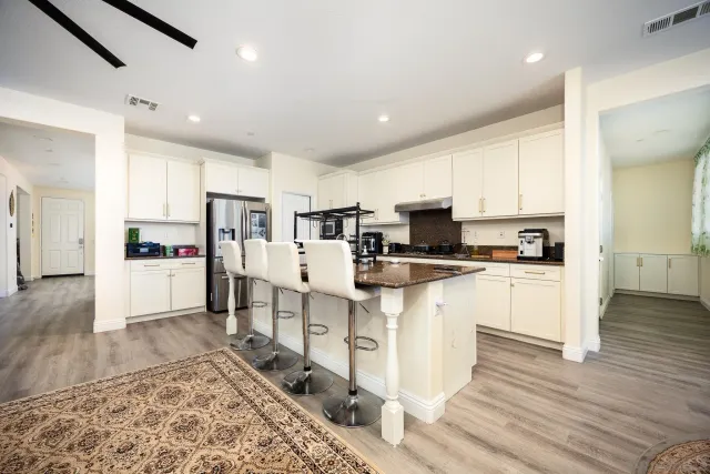a living room with stainless steel appliances kitchen island granite countertop furniture wooden floor and a window