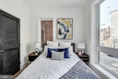 a bed room with a bed and a painting on the wall