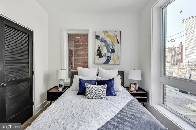 a bed room with a bed and a painting on the wall