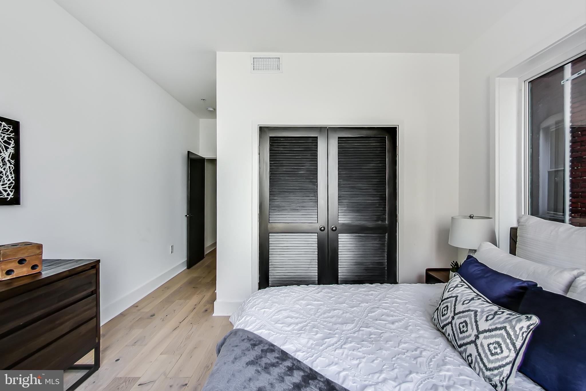 207 Florida Avenue Northwest, Unit 1 Washington, DC 20001 - Photo 14 of 26 a bedroom with a bed and a couch