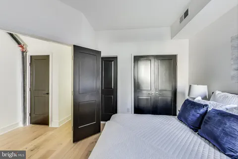 a bedroom with a bed and a refrigerator