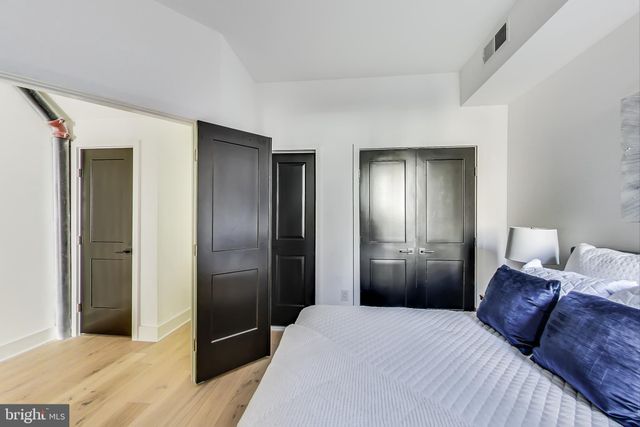 a bedroom with a bed and a refrigerator