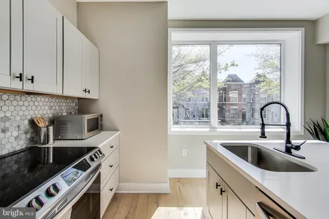 a kitchen with a sink a stove and cabinets