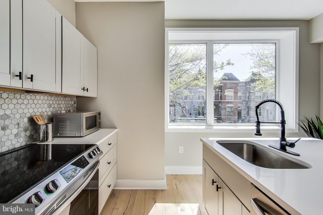 a kitchen with a sink a stove and cabinets