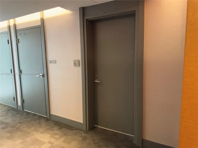 a view of a hallway with a livingroom and a bathroom