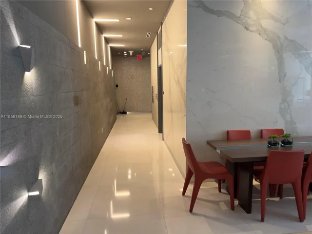 a view of hallway with furniture and a refrigerator