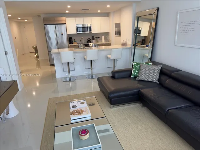 a living room with a couch and a dining table with kitchen view