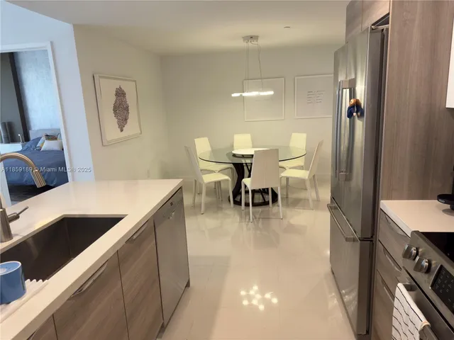 a kitchen with a table chairs and a refrigerator