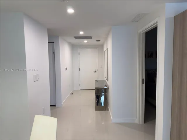 a view of hallway with furniture and a refrigerator