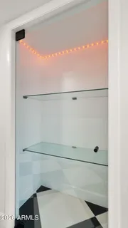 a walk in closet with wooden floor