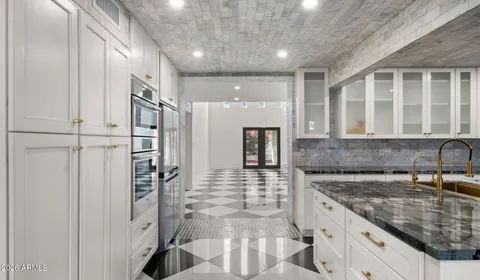a kitchen with a sink and a stove top oven with wooden floor