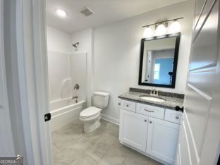 1333 Mooty Bridge Road, Unit 2 LaGrange, GA 30240 - Photo 9 of 17 a bathroom with a granite countertop toilet a sink and a mirror