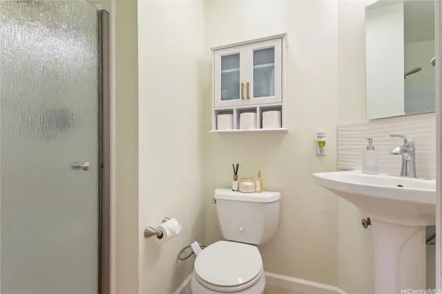 a bathroom with a toilet a sink and mirror