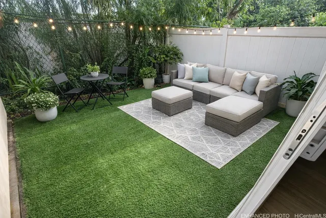 a view of a couches in the patio with a small yard