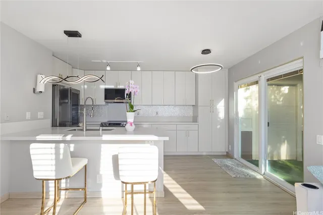 a kitchen with kitchen island granite countertop a sink cabinets and stainless steel appliances