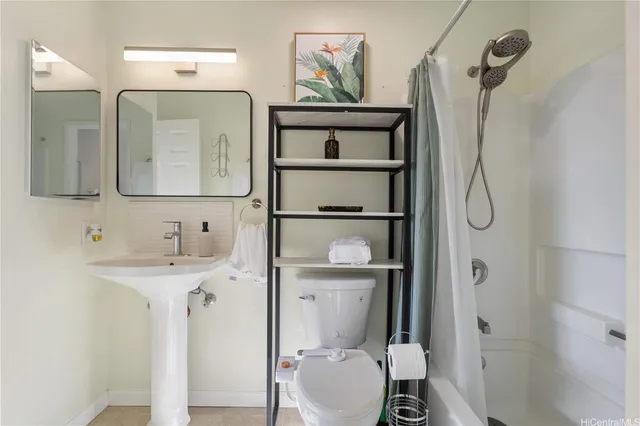 a bathroom with a granite countertop shower sink vanity mirror and toilet