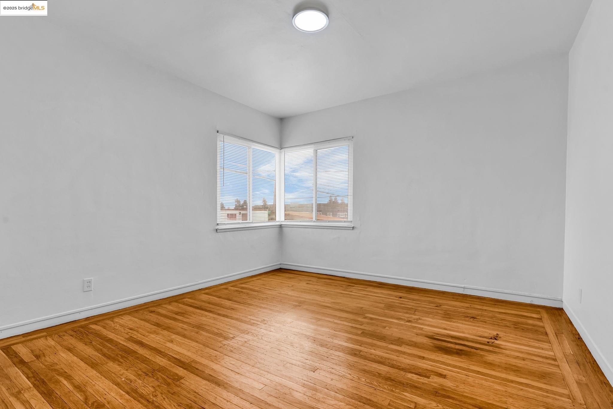 5492 Ruth Avenue Oakland, CA 94601 - Photo 13 of 16 Spare room featuring light wood-style floors and baseboards