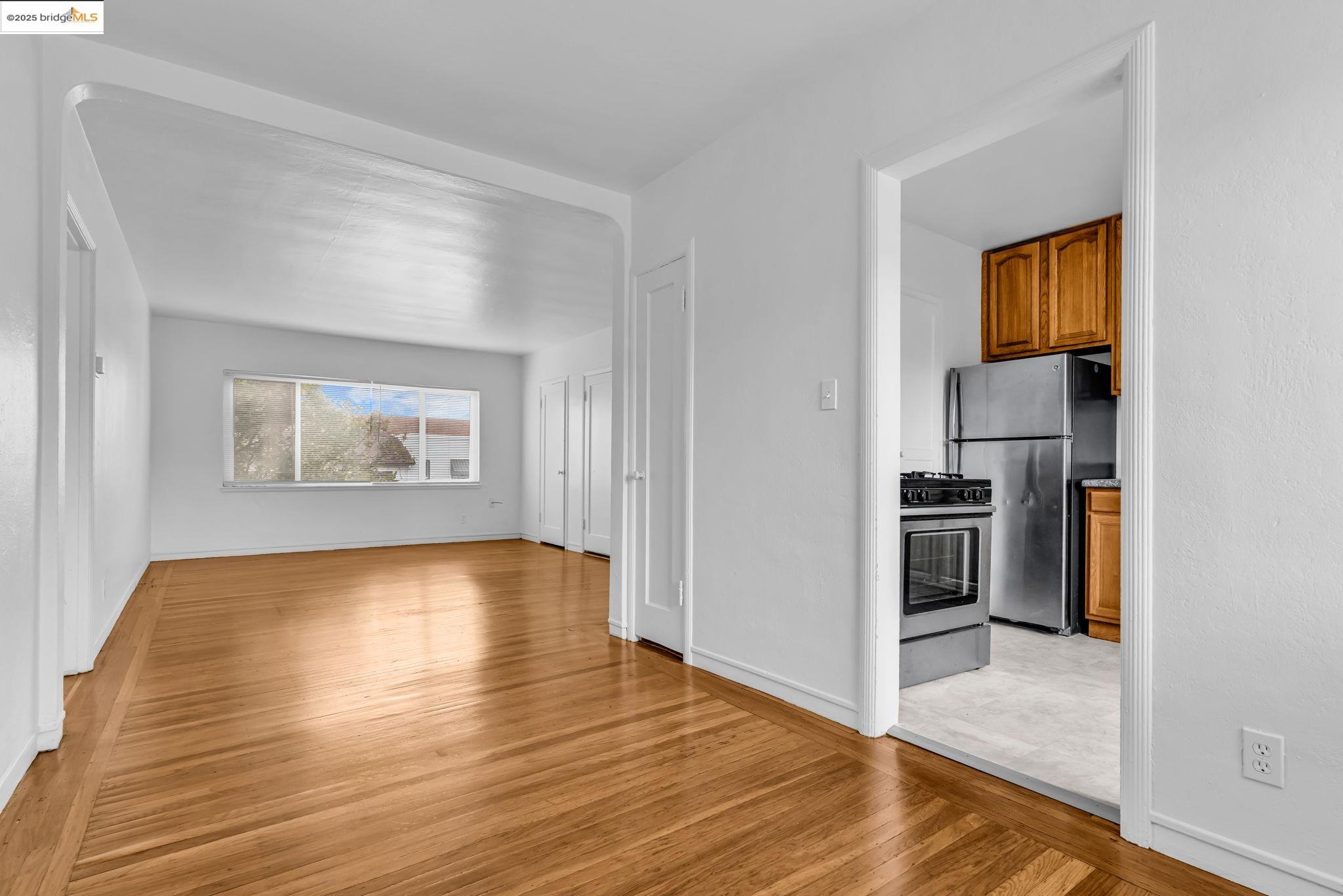 5492 Ruth Avenue Oakland, CA 94601 - Photo 4 of 16 a view of a hallway with wooden floor and a living room
