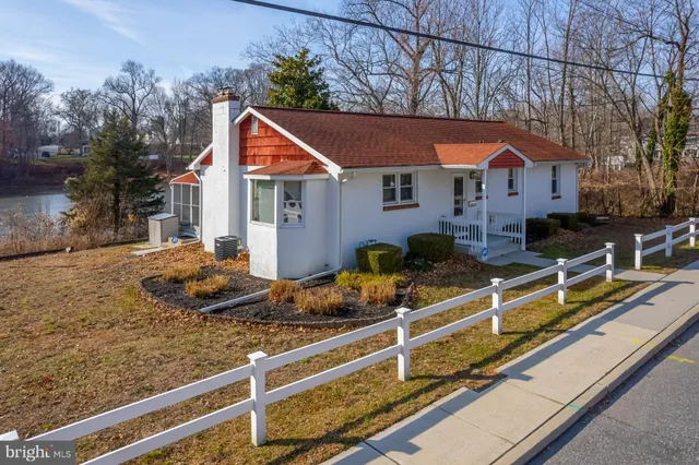 a front view of house with yard and trees in the background