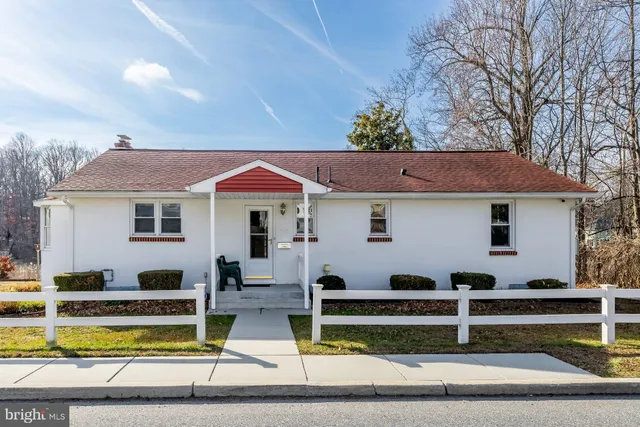 a view of house with swimming pool and chairs