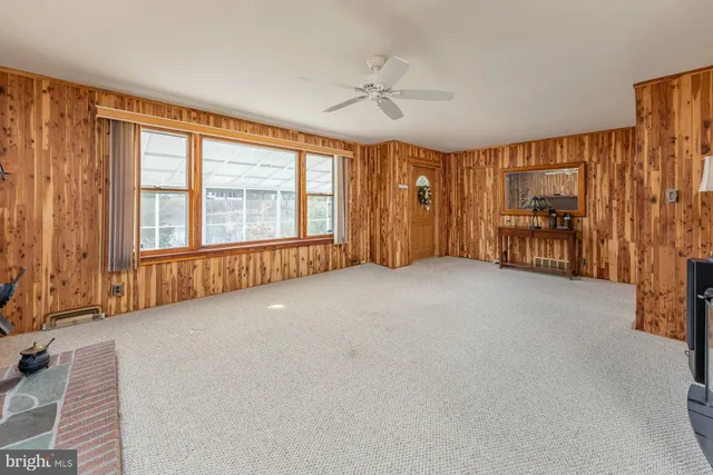a view of a livingroom with furniture and a ceiling fan