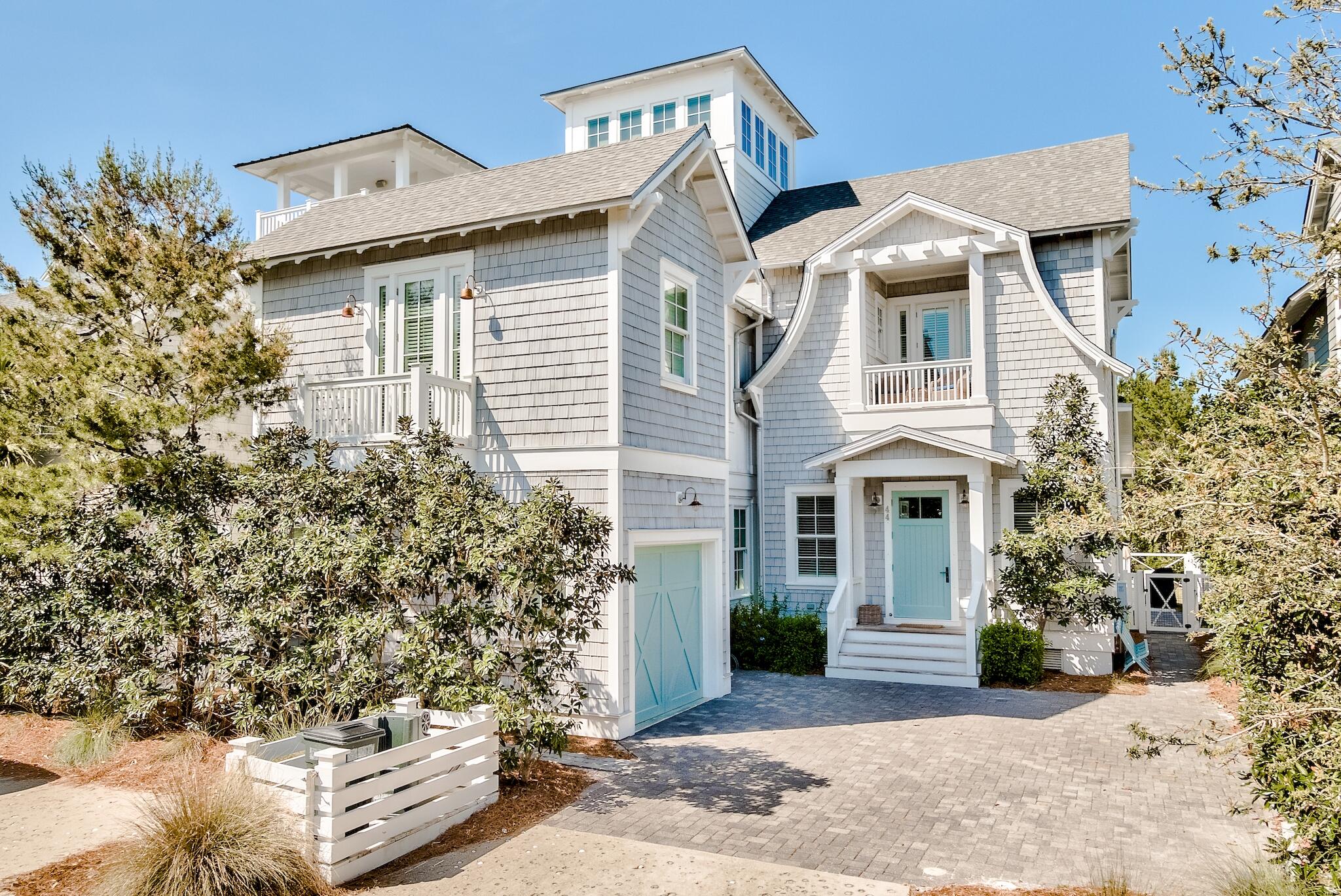 a view of a white house with large windows and a yard