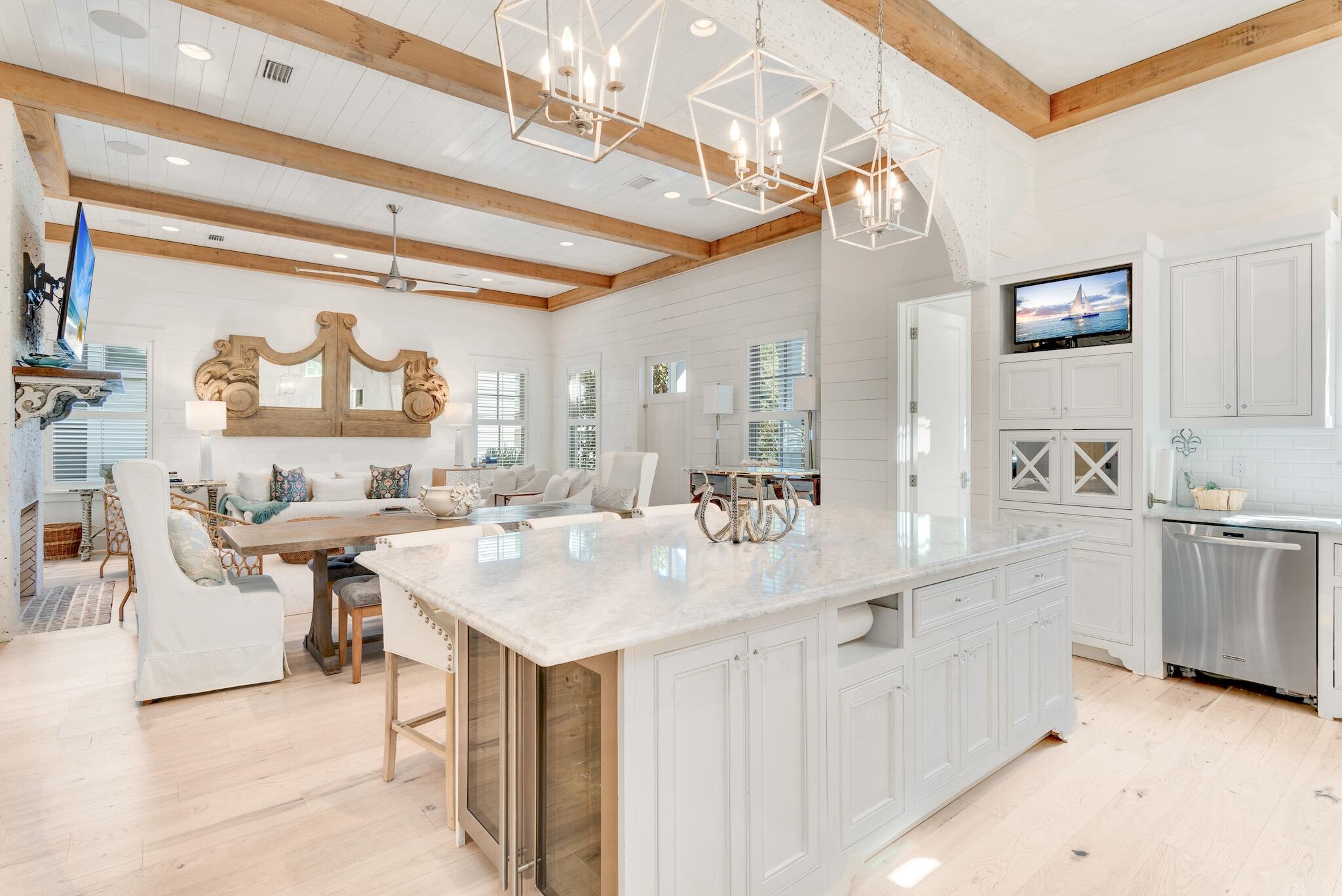 44 Tidepool Lane Watersound, FL 32461 - Photo 12 of 34 a large white kitchen with a sink and dishwasher a kitchen island with chairs