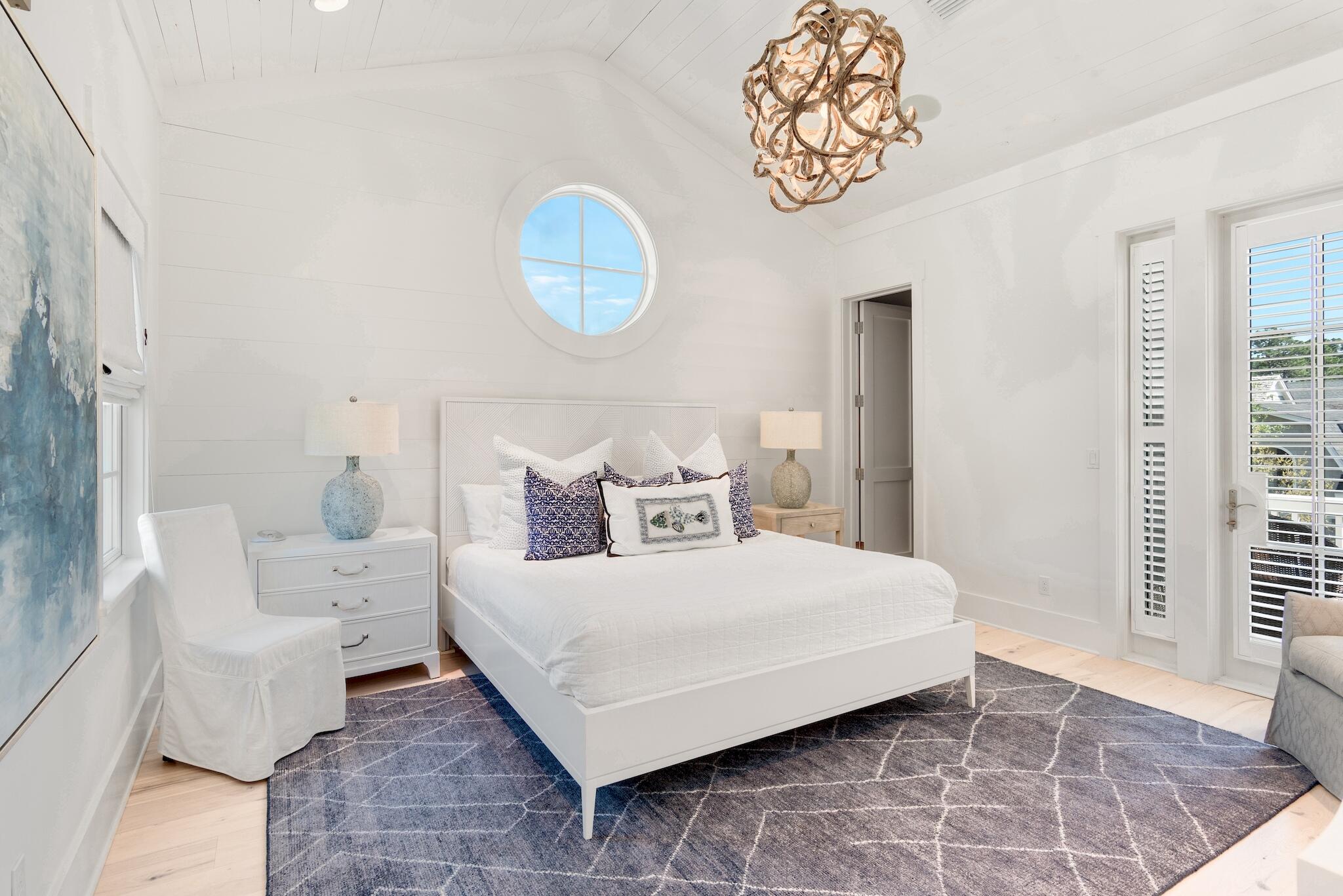 44 Tidepool Lane Watersound, FL 32461 - Photo 21 of 34 a bedroom with a bed and a chandelier