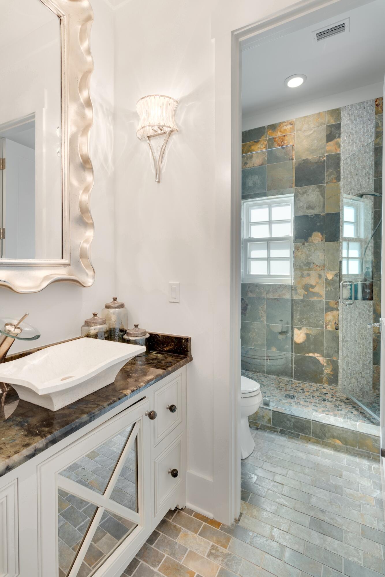 44 Tidepool Lane Watersound, FL 32461 - Photo 23 of 34 a bathroom with a granite countertop sink a toilet a mirror and shower
