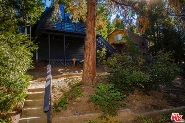 a view of a house with a small yard and tree s