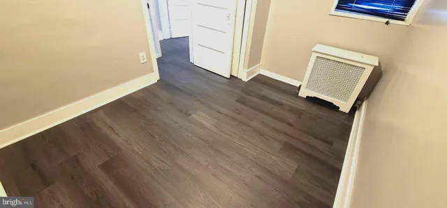 an empty room with wooden floor and entrance