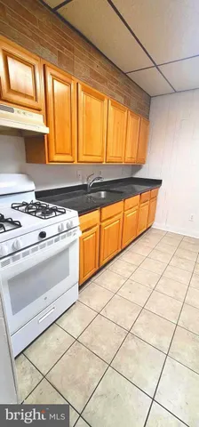 a kitchen with stainless steel appliances a stove a sink and next to a window