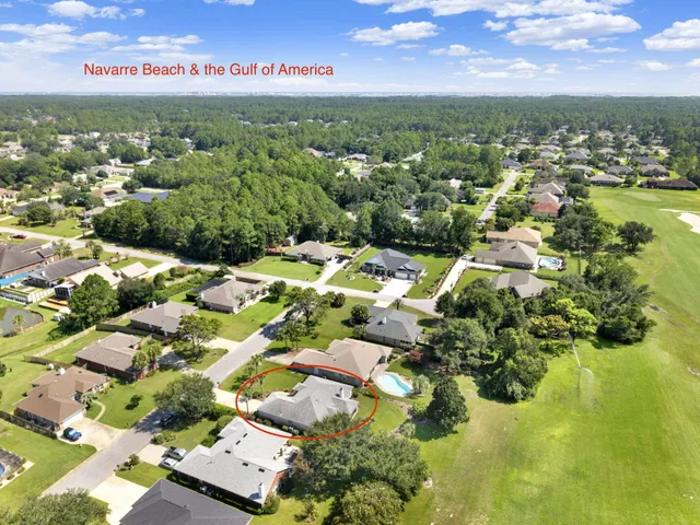 an aerial view of residential houses with outdoor space and trees