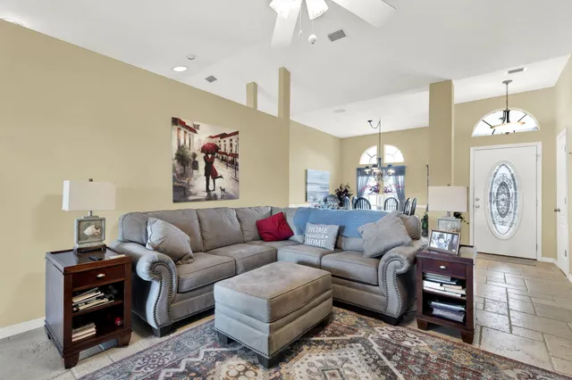 a living room with furniture a clock and a chandelier