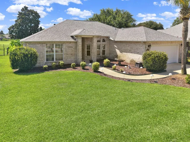 a front view of a house with a garden and patio