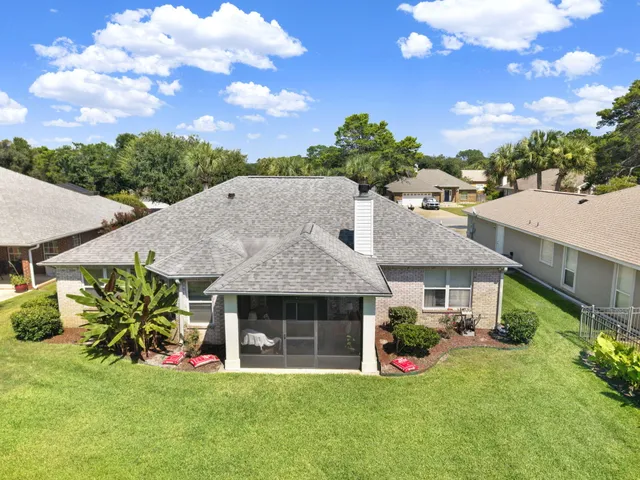 a aerial view of a house with table and chairs with wooden fence