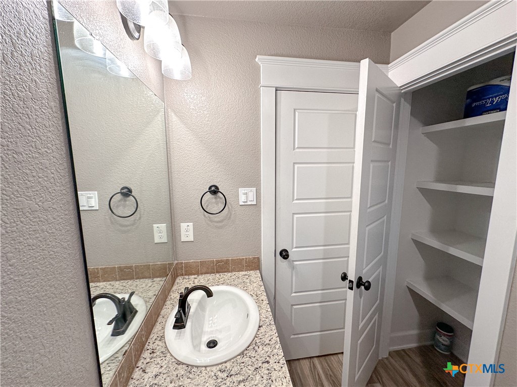 3533 Hooten Bend Kempner, TX 76539 - Photo 32 of 47 a bathroom with a granite countertop sink a mirror and vanity