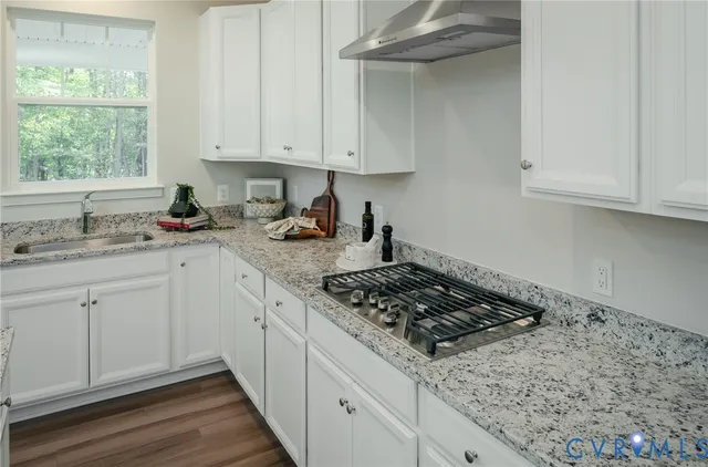 a kitchen with stainless steel appliances granite countertop a sink stove and cabinets