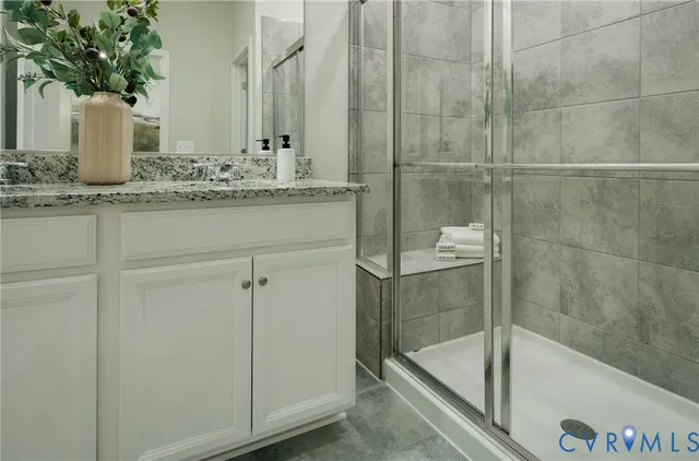a bathroom with a granite countertop sink and a bathtub