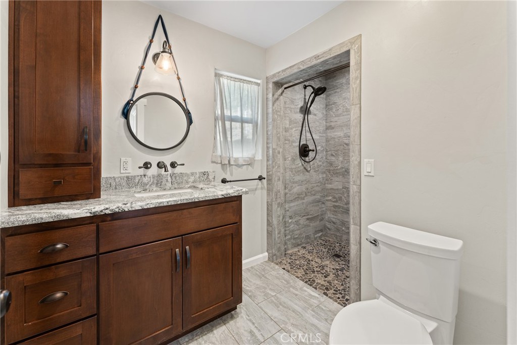 30300 Live Oak Canyon Road Redlands, CA 92373 - Photo 26 of 67 a bathroom with a granite countertop sink toilet a mirror and shower