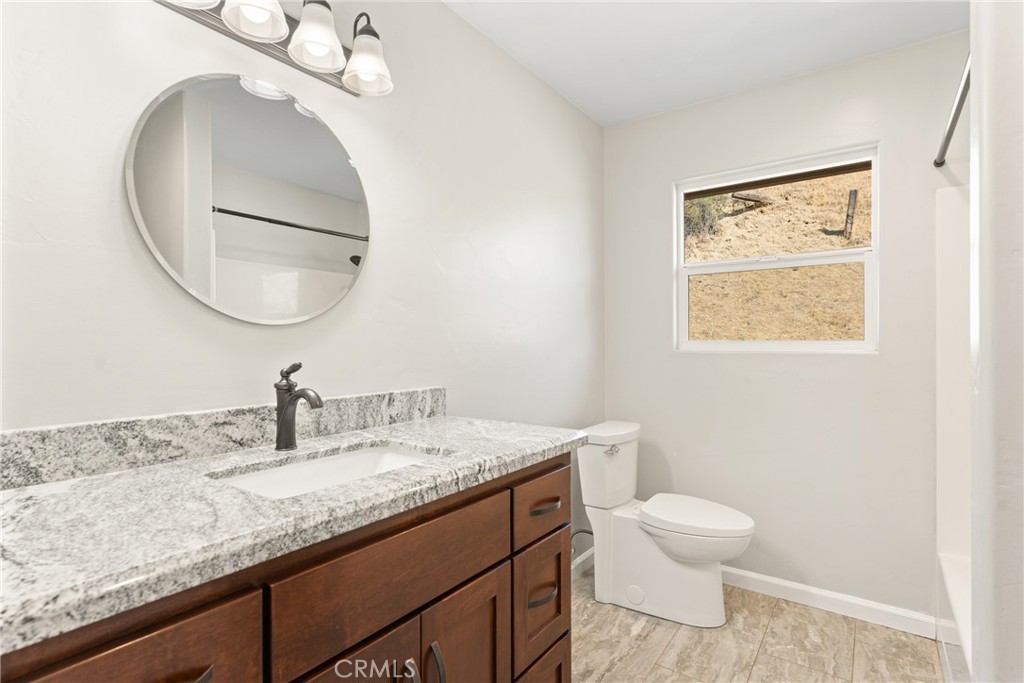 30300 Live Oak Canyon Road Redlands, CA 92373 - Photo 30 of 67 a bathroom with a granite countertop toilet sink and mirror
