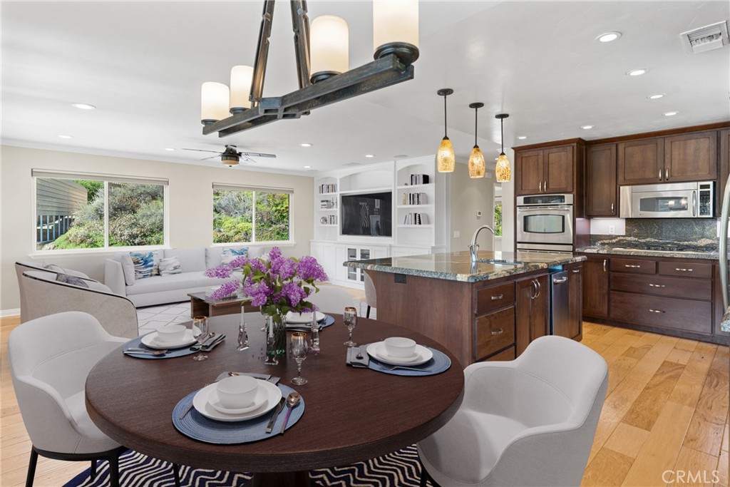 30300 Live Oak Canyon Road Redlands, CA 92373 - Photo 45 of 67 a kitchen with stainless steel appliances kitchen island granite countertop a stove a sink dishwasher a dining table and chairs with wooden floor