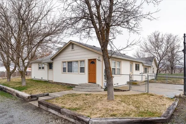 a view of a yard in front of a house with large trees
