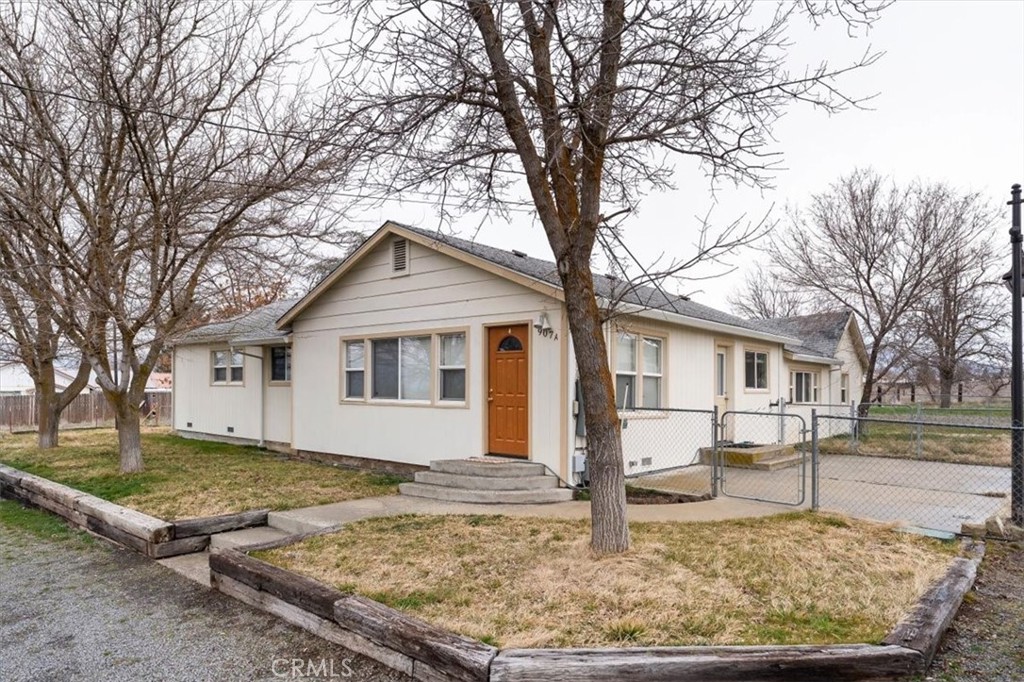 a view of a yard in front of a house with large trees