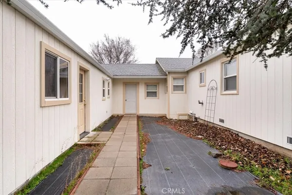 a white house that has a tree in front of it