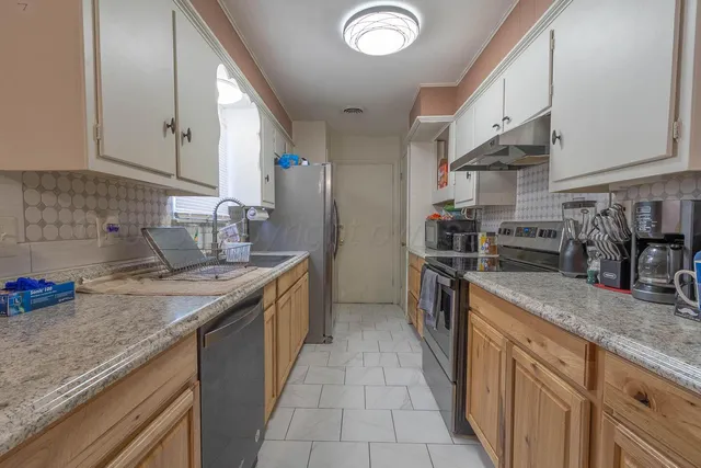 a kitchen with stainless steel appliances granite countertop a sink stove and cabinets