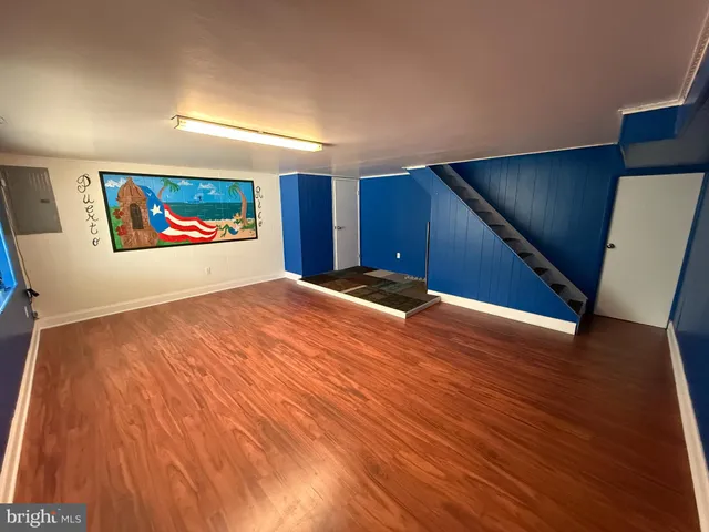 a view of a room with wooden floor and painting on the wall