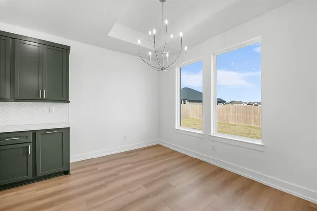 an empty room with a ceiling fan and windows