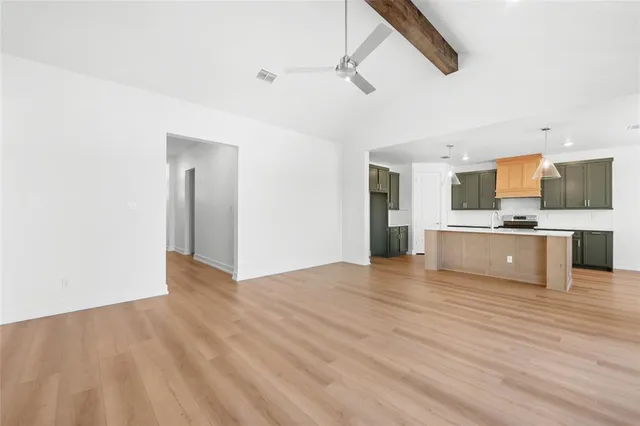 a kitchen with stainless steel appliances a sink stove and wooden floor